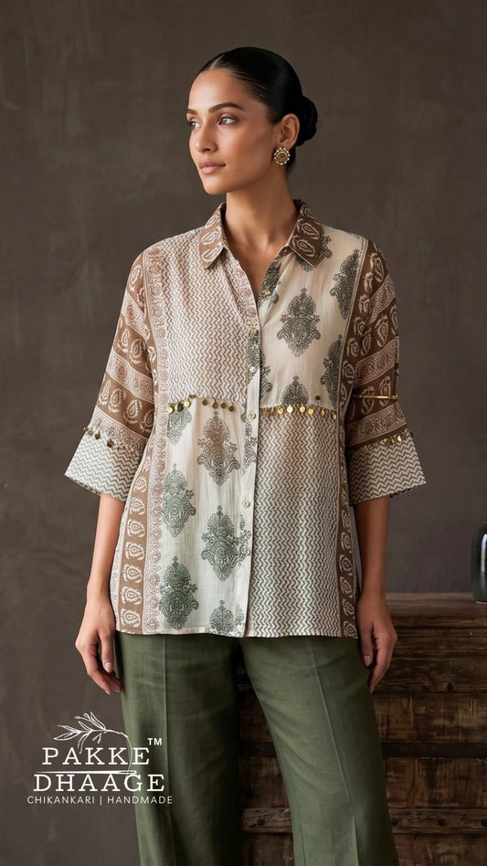 A woman modeling a beige and brown printed kurta with green leaf motifs and gold embroidery, paired with olive green trousers, set against a rustic brown background. The brand logo 'PAKKE DHAAGE' is visible in the bottom left corner.