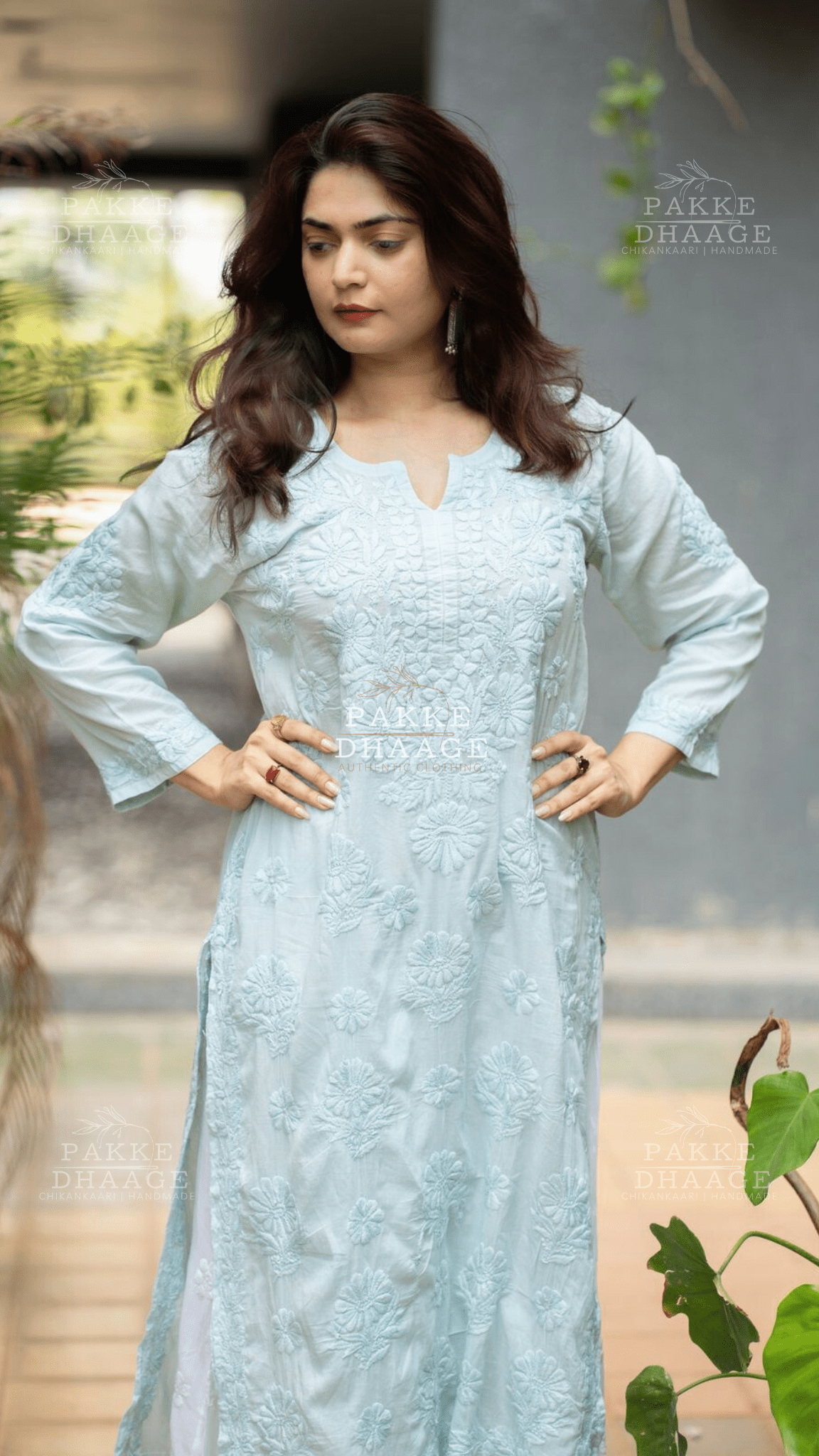 Woman wearing a light blue aqua chikankari hand embroidered kurti with a blurred background